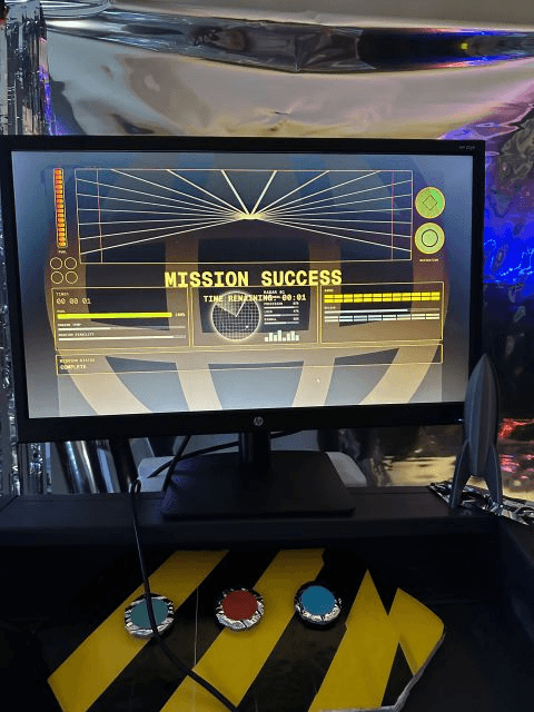 Escape Room event station with a Mission Success screen and three physical puzzle buttons.